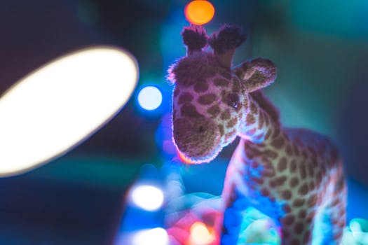 pexels-photo-733539-733539 Close-up of a cute stuffed giraffe toy with colorful bokeh background lighting.